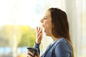 Profile of a woman yawning in the morning